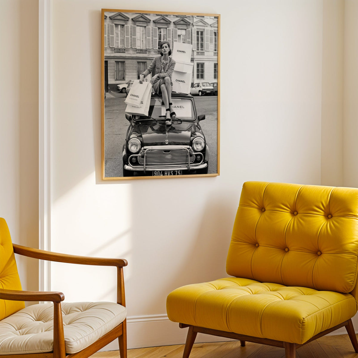 Woman in tweed suit on vintage mini car print shown in a gold frame above a mustard yellow tufted armchair