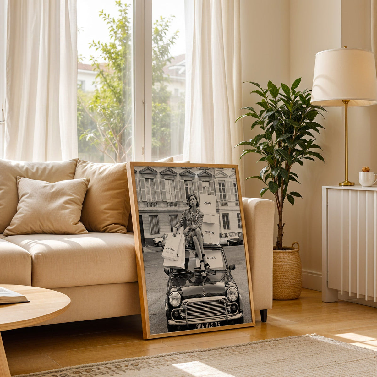 Woman in tweed suit on vintage mini car print in a light oak frame leaning on a cream sofa beside a floor lamp