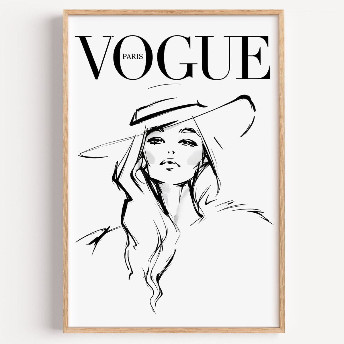 Woman in wide brim hat fashion sketch print in a light oak frame on a plain white wall
