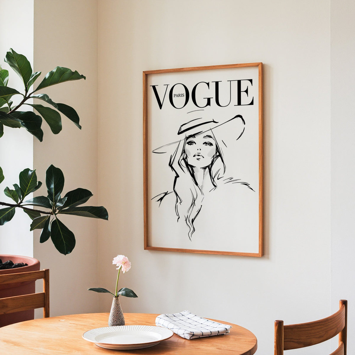 Woman in wide brim hat fashion sketch print in a teak frame above a round wooden dining table