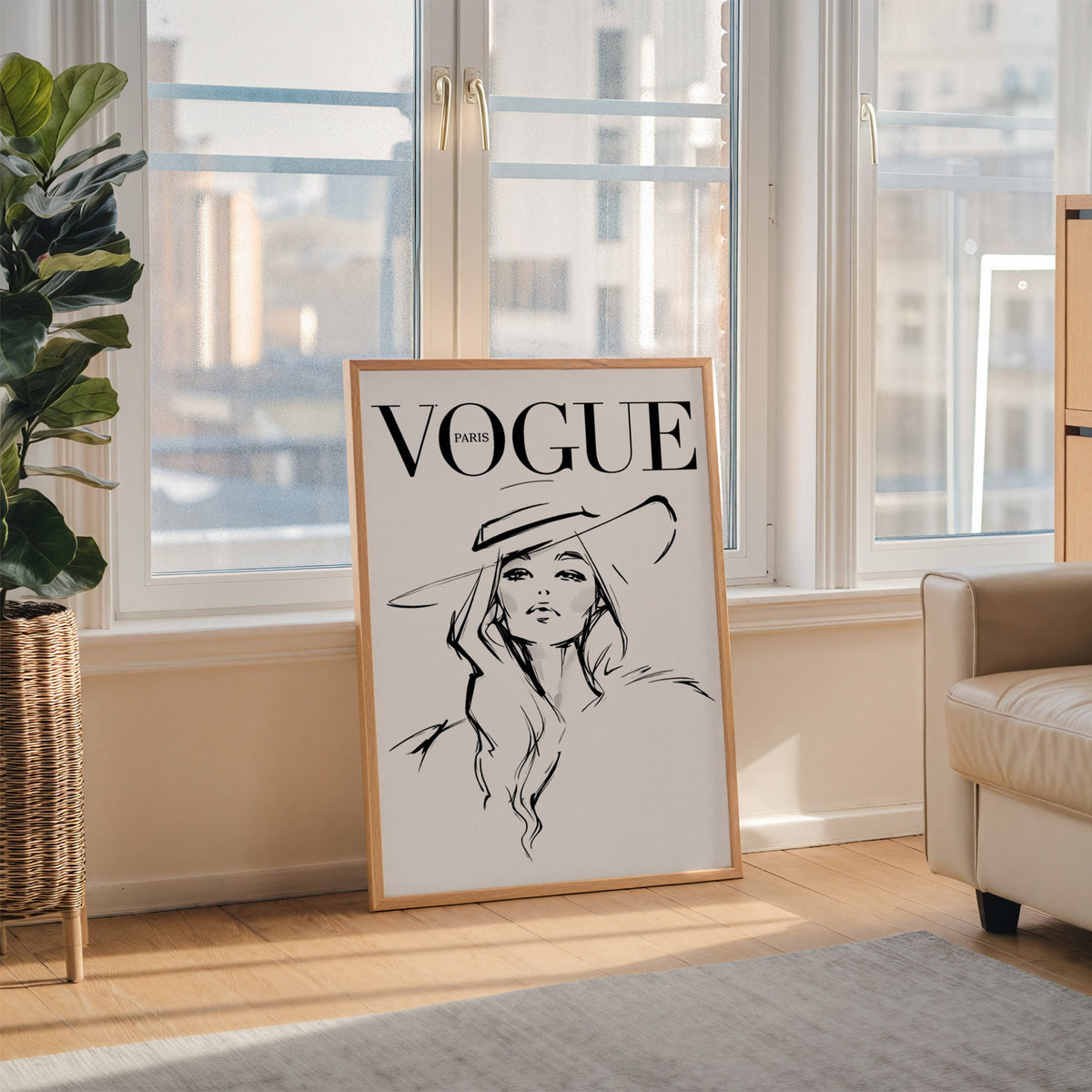 Woman in wide brim hat fashion sketch print in an oak frame leaning on the floor beside a fiddle leaf fig