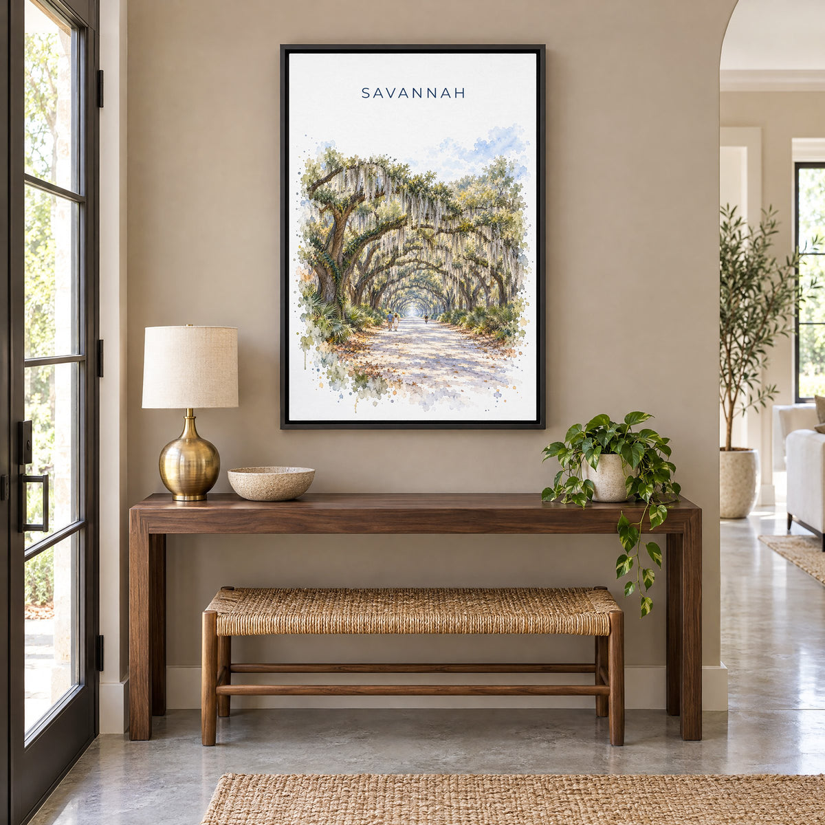 Wormsloe Savannah watercolor print as a black floater canvas above a walnut console and woven bench in an entryway