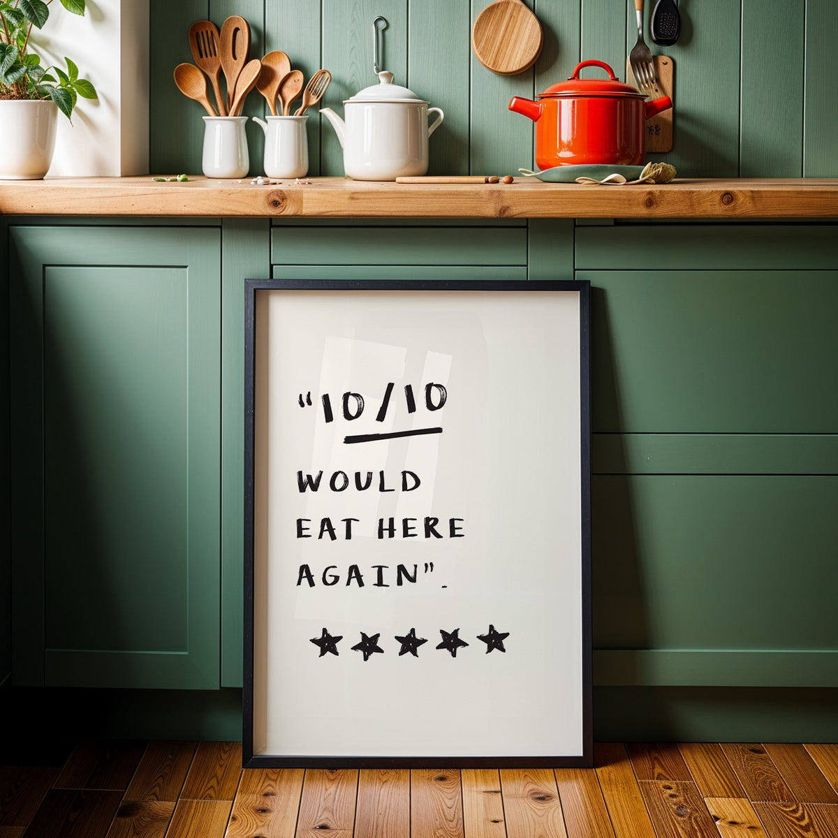 Would eat here again print in a black frame against sage green kitchen cabinets