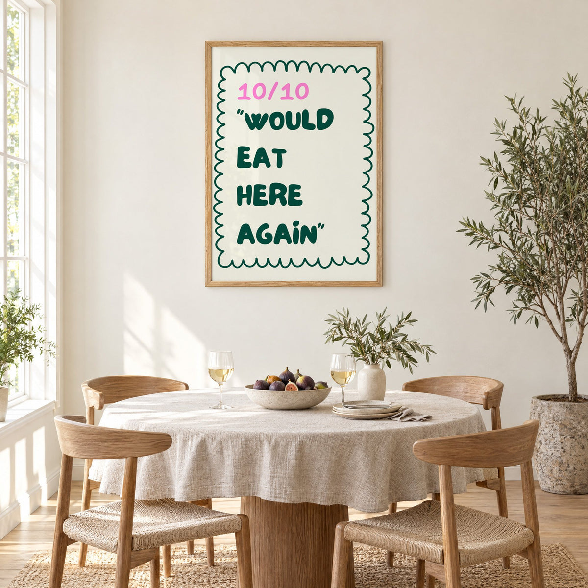 Would Eat Here Again 10/10 print in an oak frame above a round linen-covered dining table with figs and wine