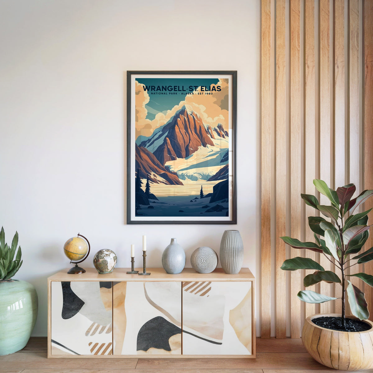 Wrangell–St. Elias National Park print in a black frame above a light wood sideboard with ceramic vases