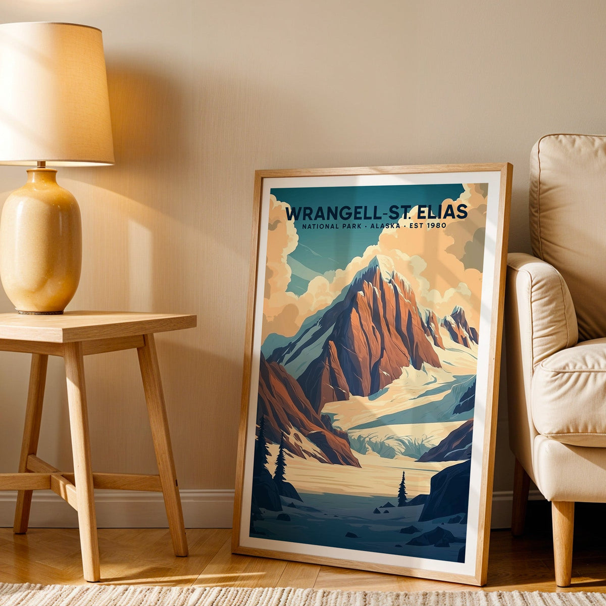 Wrangell–St. Elias print in an oak frame beside a cream armchair and an amber lamp in warm light
