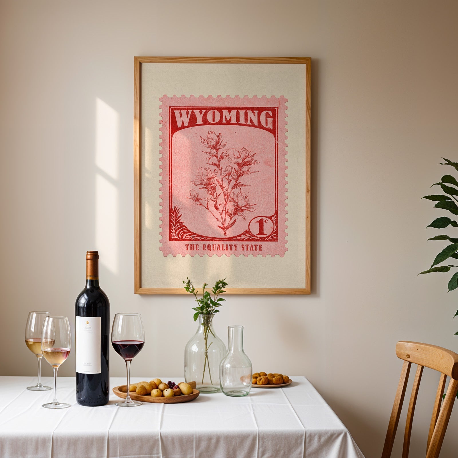 Wyoming stamp print framed on the wall above a dining table set with wine, glasses and olives
