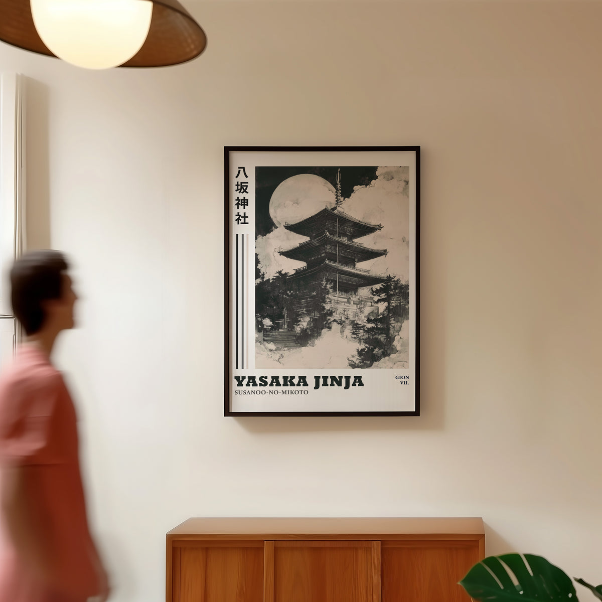 Sumi-e Yasaka pagoda and full moon print in a black frame in a hallway under a rattan pendant