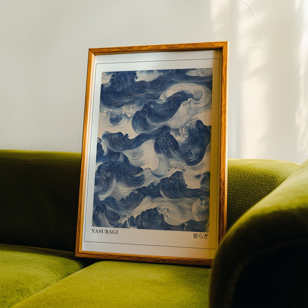 Indigo woodblock Yasuragi waves print in an oak frame propped on a green velvet sofa