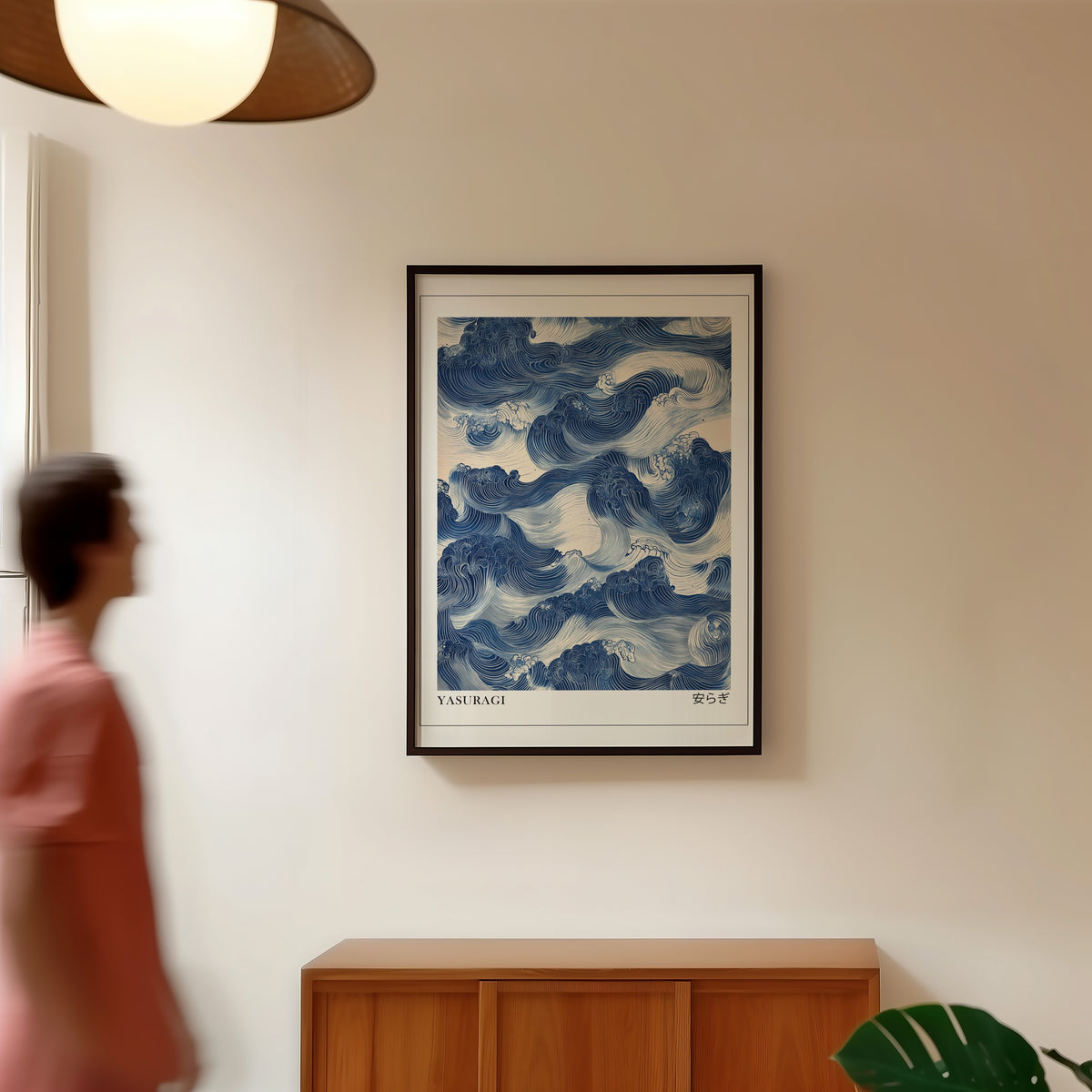 Indigo woodblock Yasuragi waves print in a black frame in a hallway under a rattan pendant
