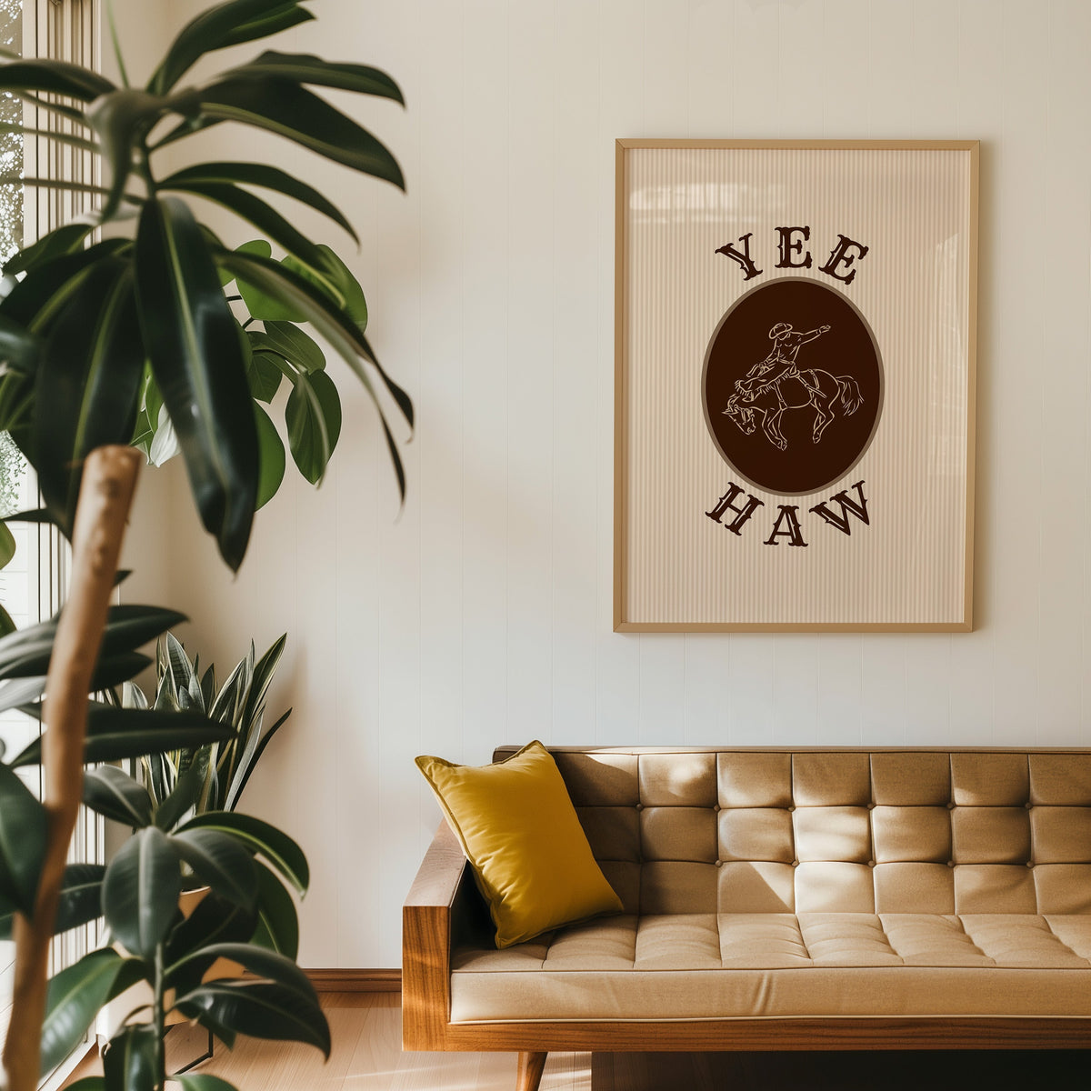 Yee Haw bronco cameo print in an oak frame above a tan leather sofa