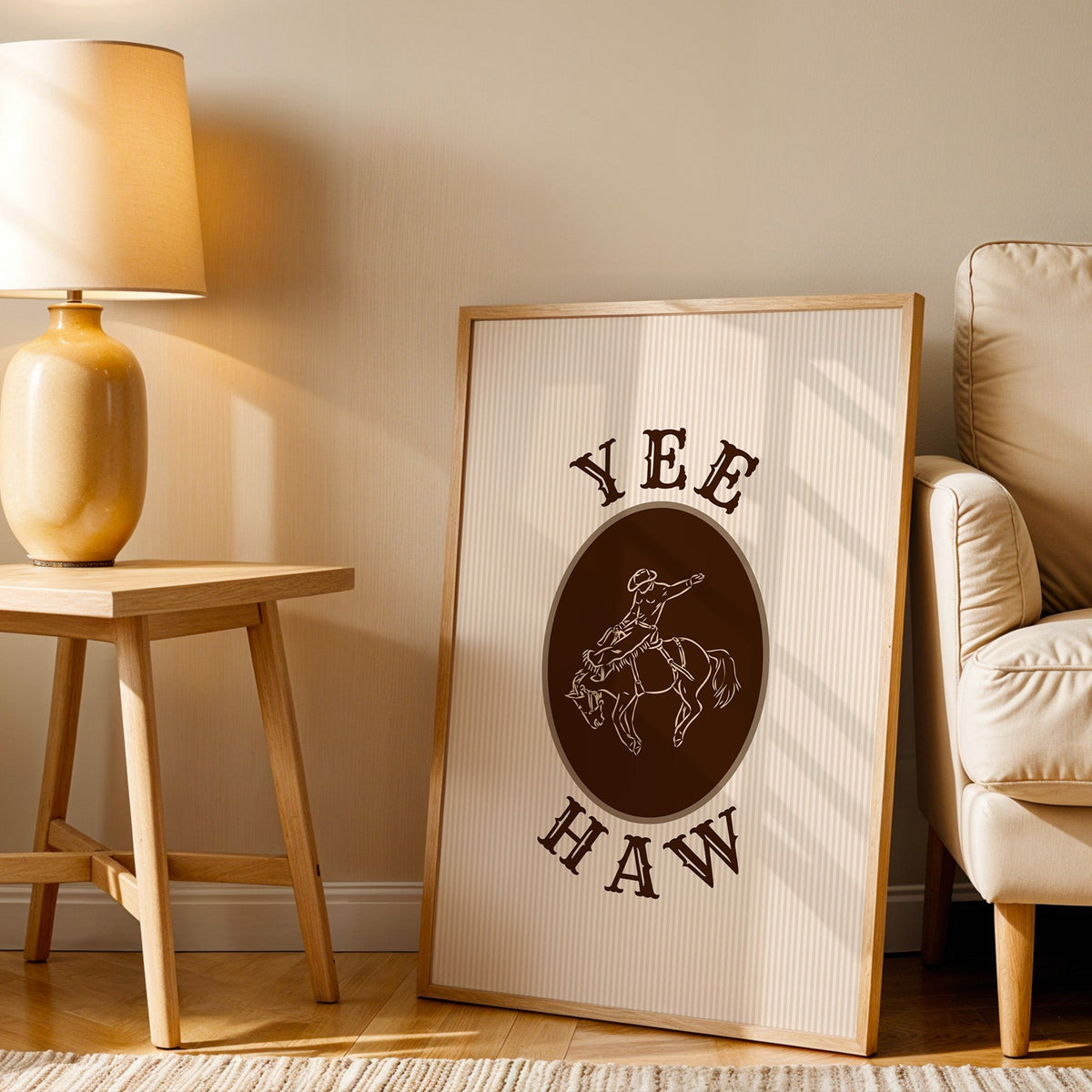 Yee Haw bronco cameo print in an oak frame beside an amber ceramic lamp