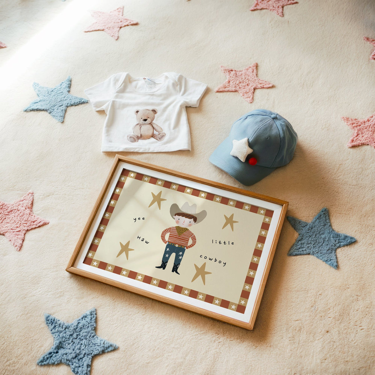 Landscape yee haw cowboy star border nursery print in a matted oak frame on a star rug with a baby tee