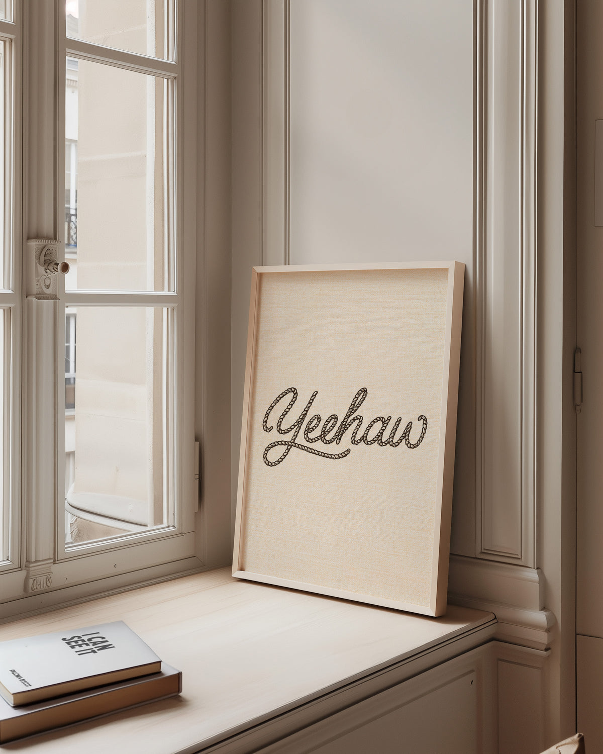 Yeehaw rope script print in a pale wood frame on a sunlit window ledge