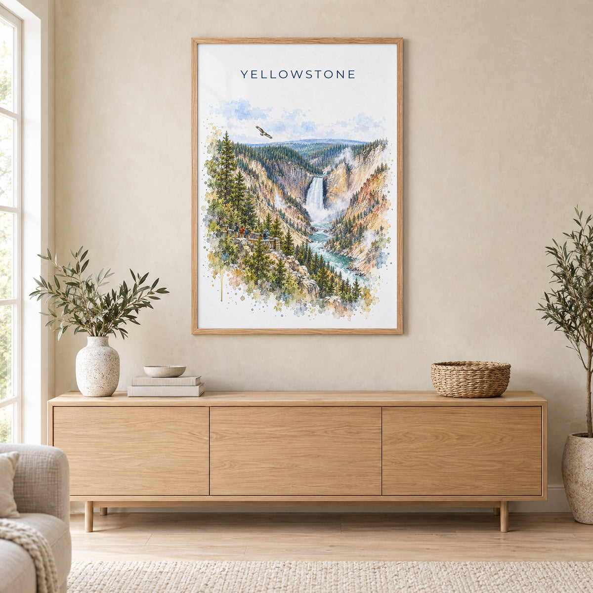 Yellowstone National Park watercolor print in an oak frame above a light wood sideboard in a Scandinavian living room