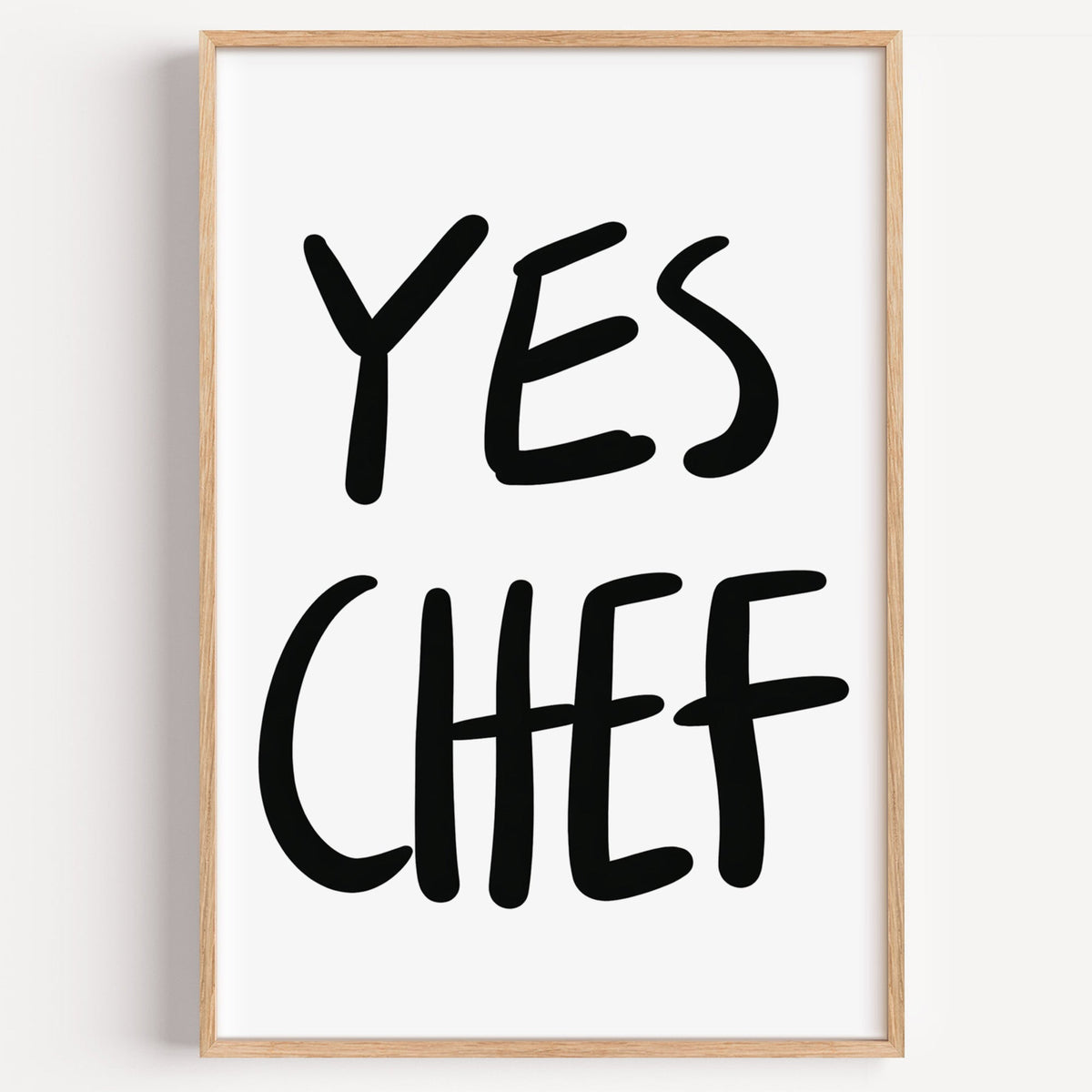 Yes Chef typography print in a light oak frame on a plain white wall