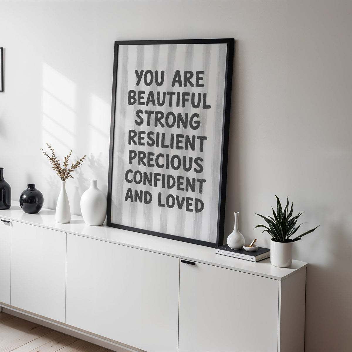 You are beautiful affirmation quote print in a black frame on a white sideboard with black and white vases