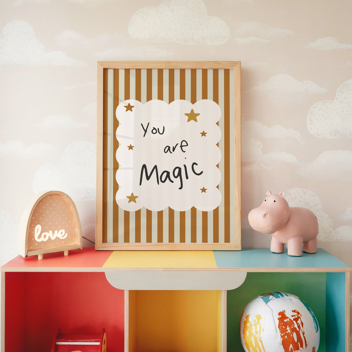 You are magic stars nursery print in an oak frame on a rainbow toy shelf against cloud wallpaper