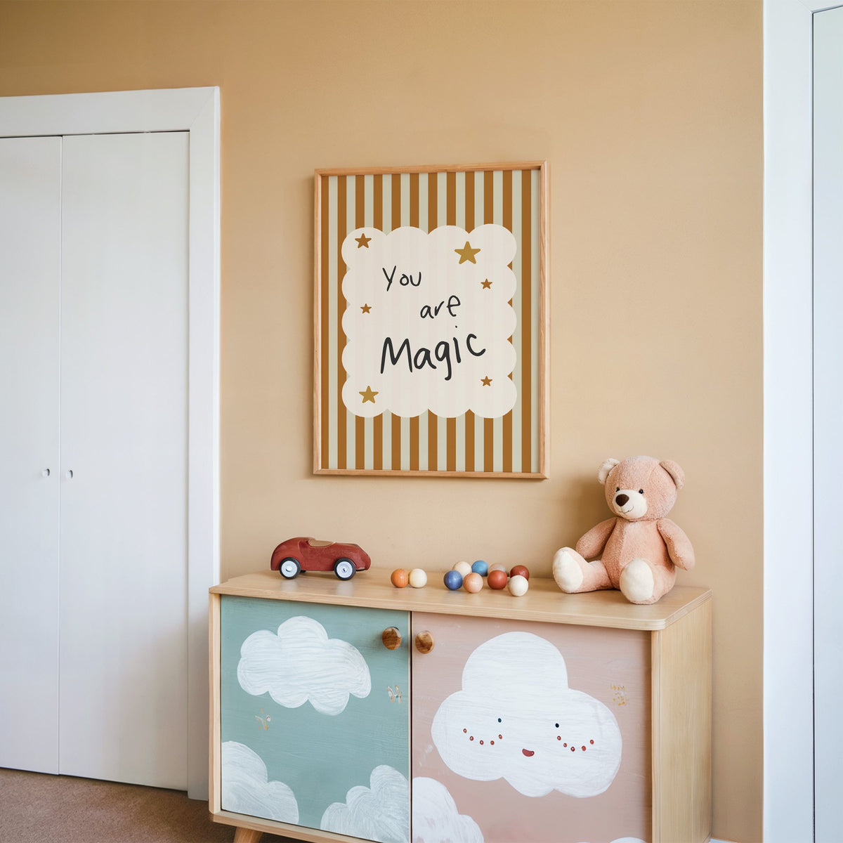 You are magic stars nursery print in an oak frame on a peach wall above a cloud-painted cabinet
