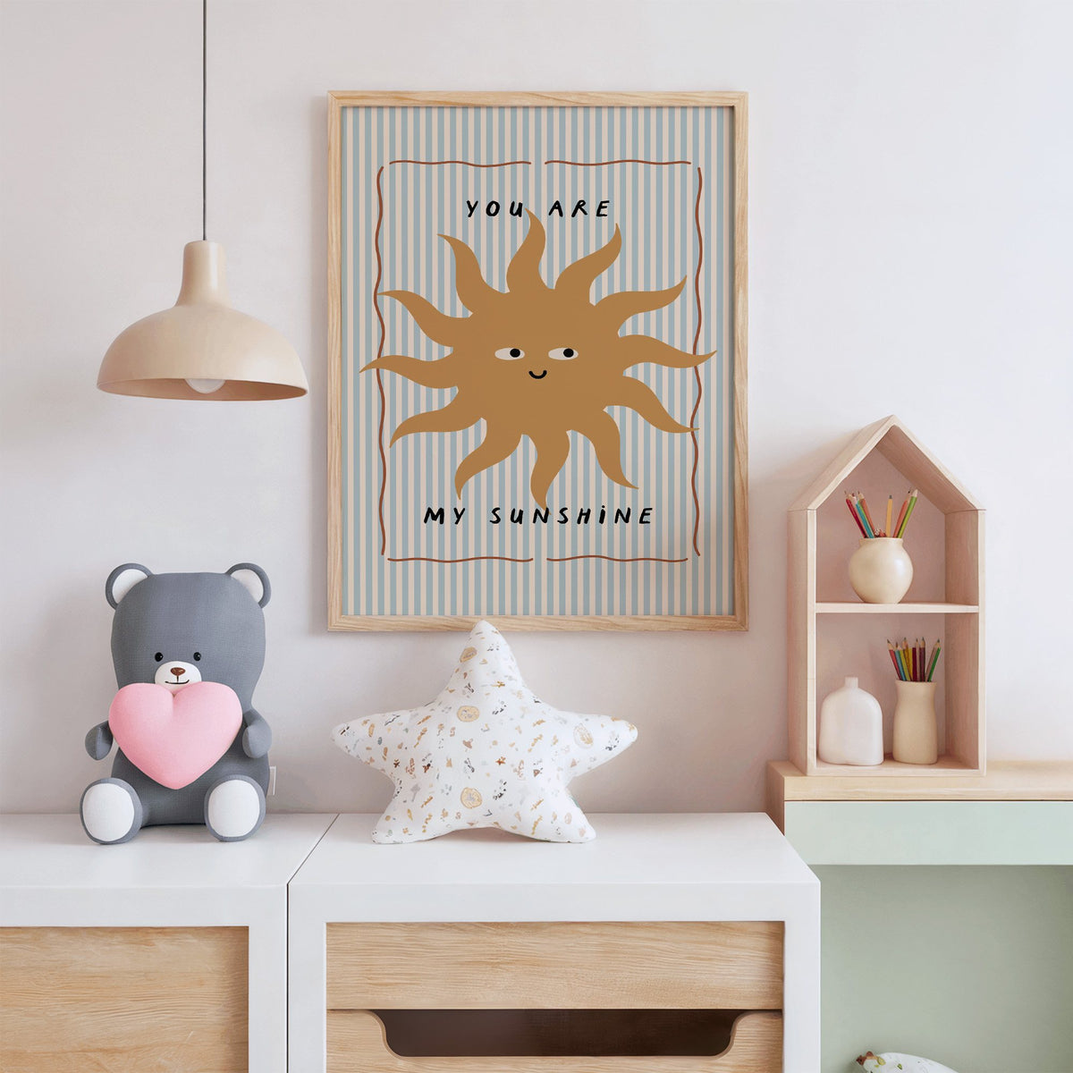 You are my sunshine sun nursery print in an oak frame above a white dresser with a star pillow and house shelf