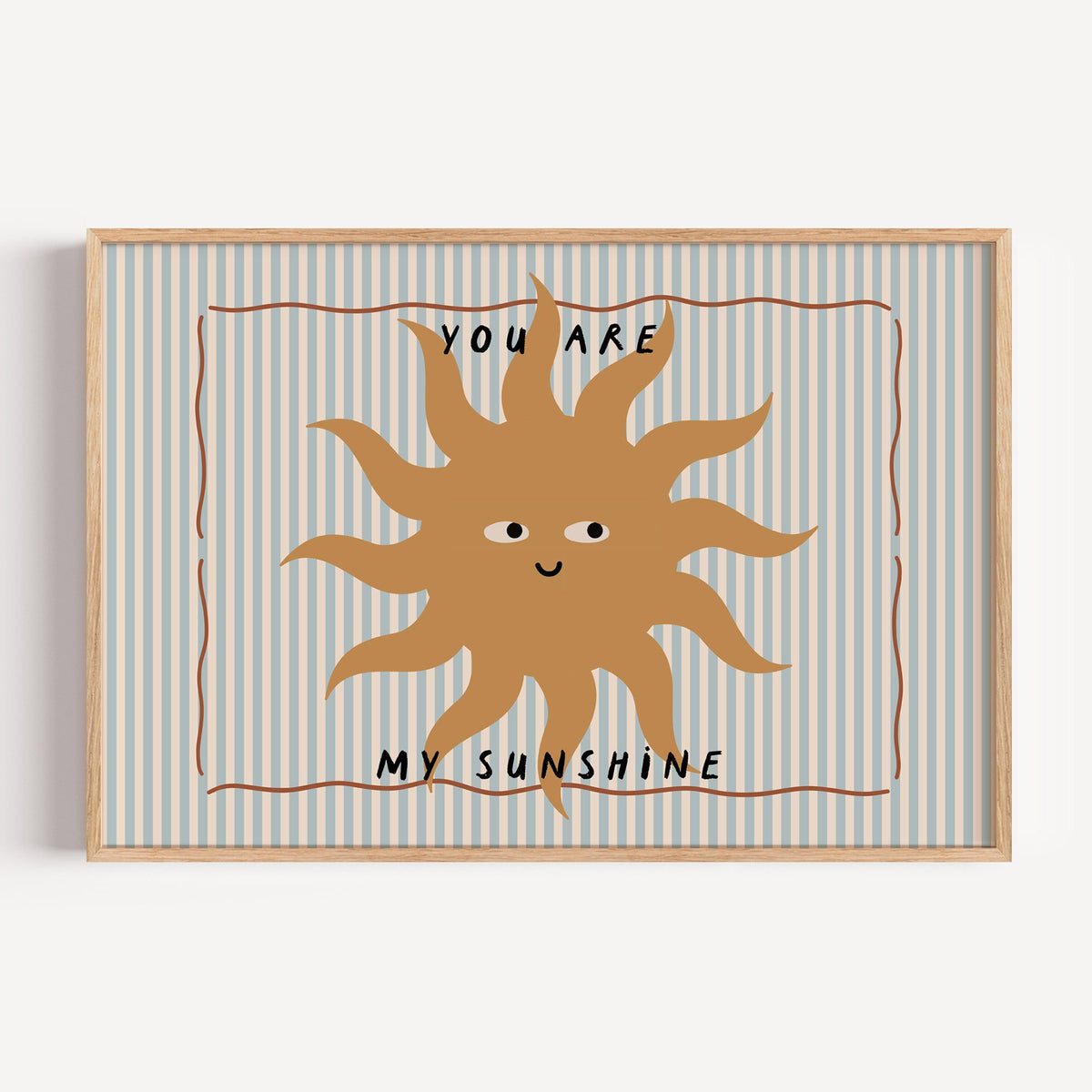 Landscape you are my sunshine sun nursery print in a light oak frame on a plain white wall