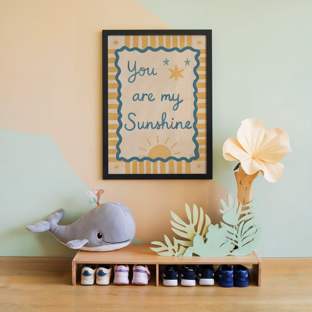 You are my sunshine wavy frame nursery print in a black frame on a mint and peach wall above a whale plush