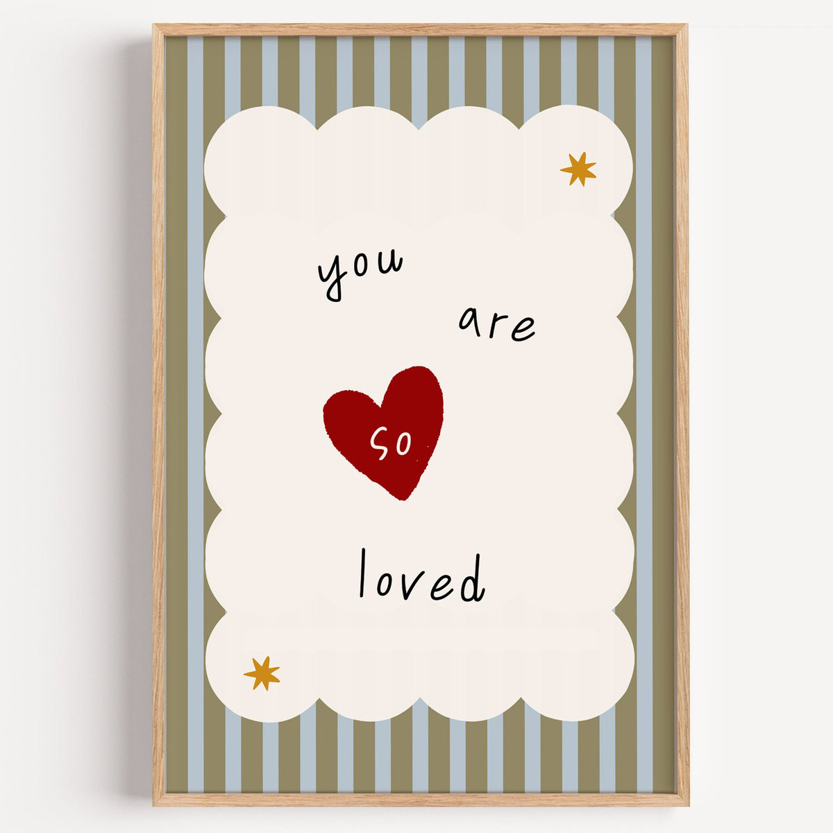 You are so loved heart nursery print in a light oak frame on a plain white wall