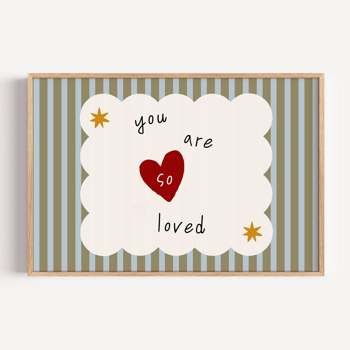 Landscape you are so loved heart nursery print in a light oak frame on a plain white wall
