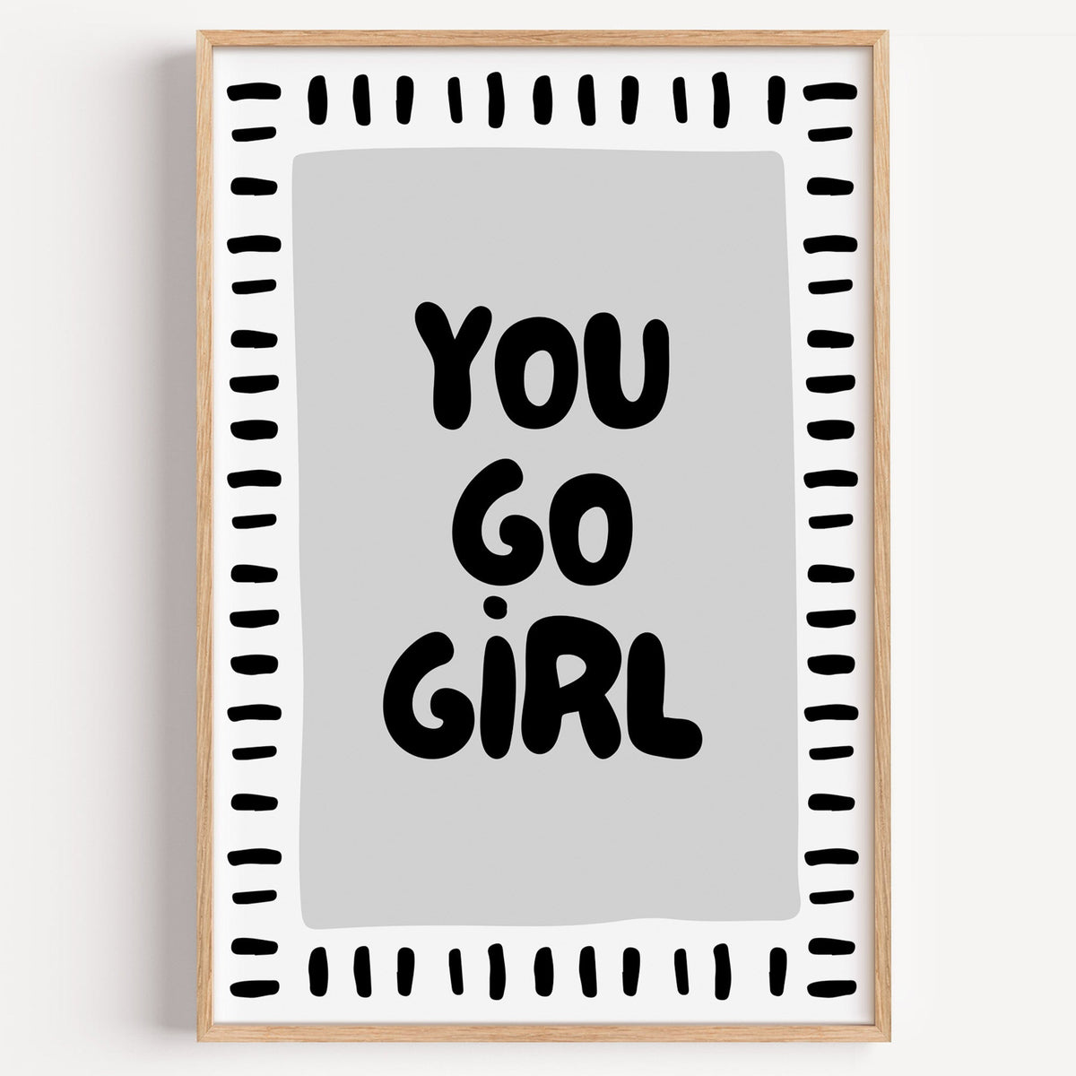 You go girl bubble letter quote print in a light oak frame on a plain white wall