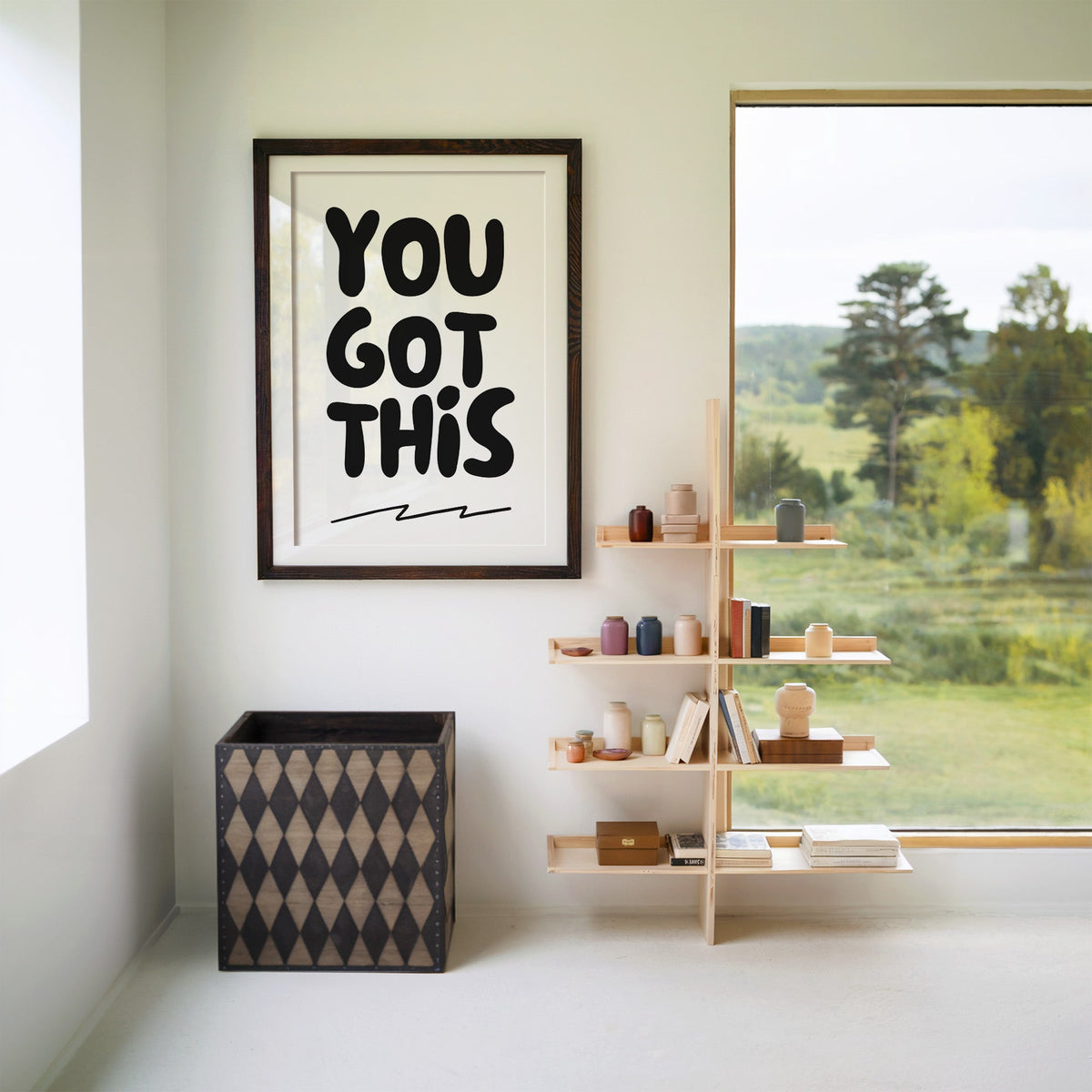 You got this bubble letter quote print in a walnut frame with a white mat beside wooden shelves and a garden window