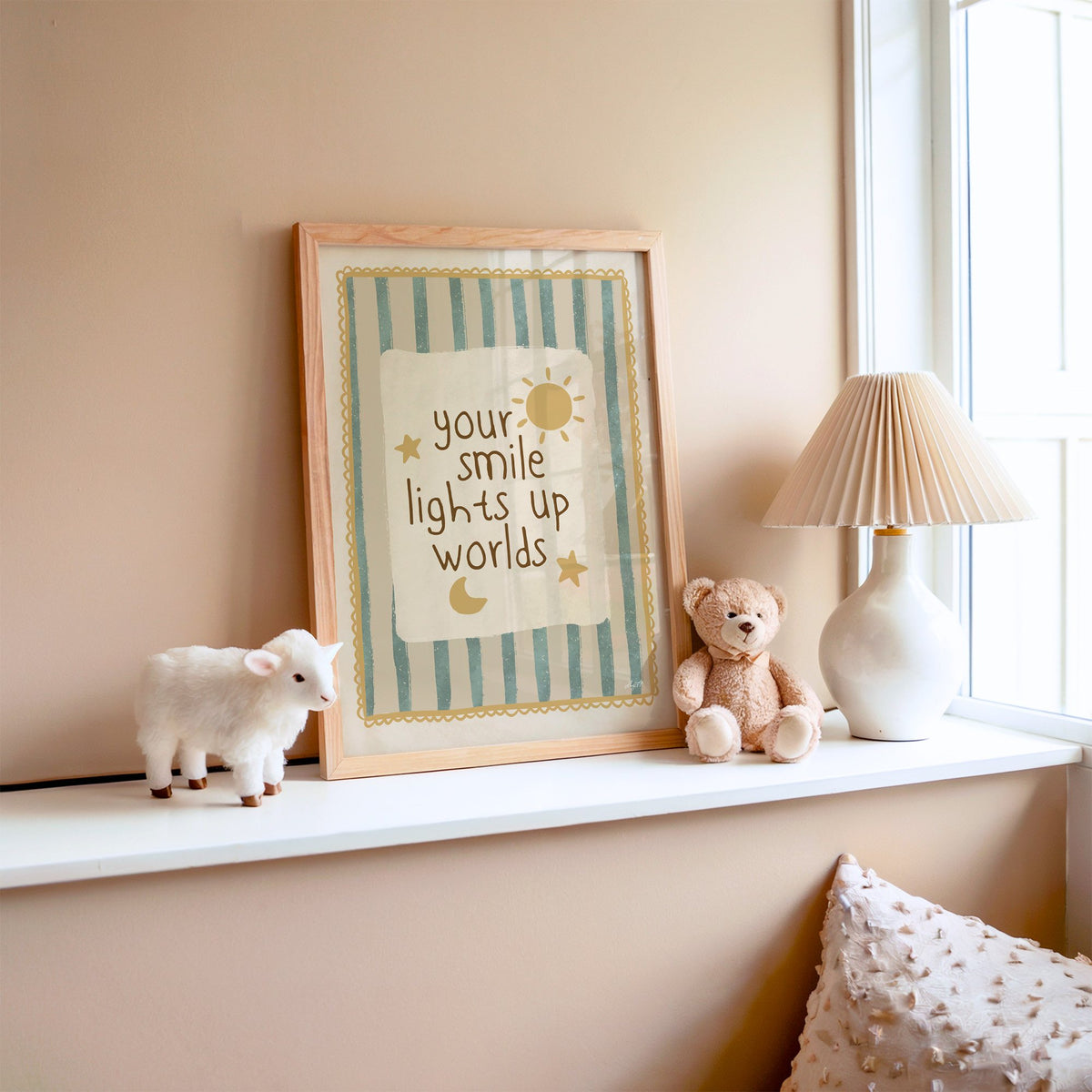 Your smile lights up worlds nursery print in an oak frame on a window ledge with a toy lamb and teddy
