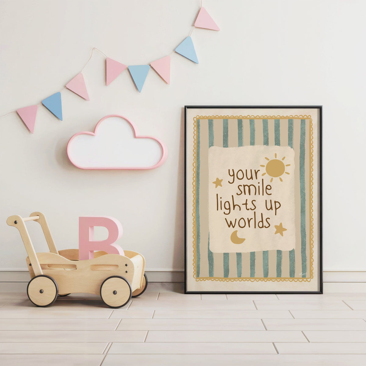 Your smile lights up worlds nursery print in a black frame under pastel bunting by a wooden baby walker