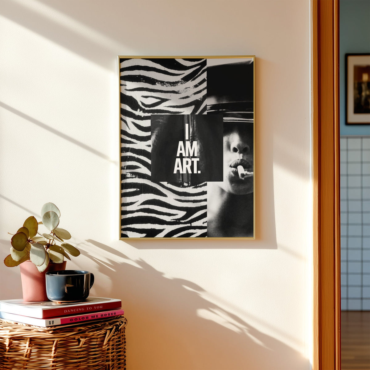Zebra stripe collage with I am art panel print shown in a gold frame above a wicker basket and stacked books