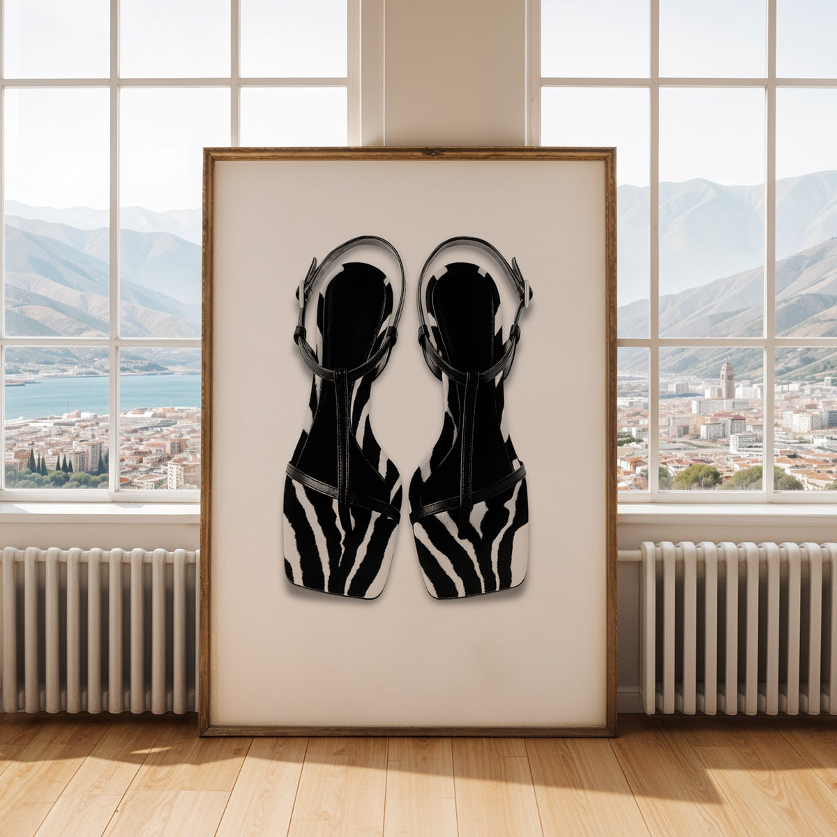 Zebra stripe T-strap sandals on white print shown in an antique gold frame by tall windows with a sea view