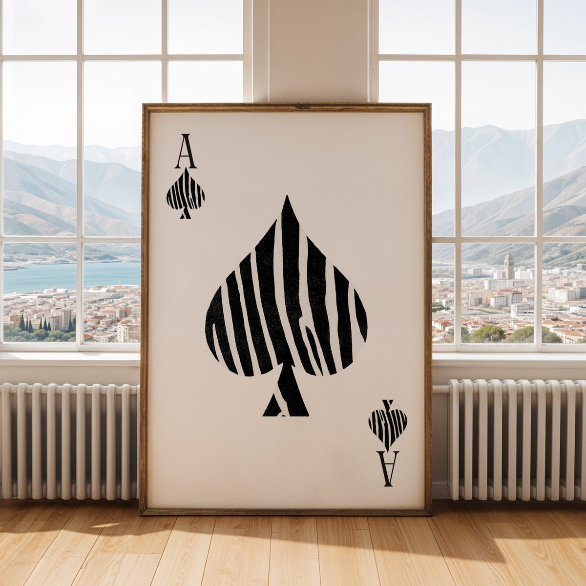 Zebra stripe ace of spades playing card print shown in an antique gold frame by tall windows with a sea view