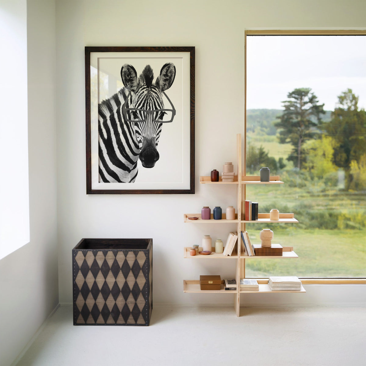 Zebra wearing black rectangular glasses print in a walnut frame with a white mat beside wooden shelves and a garden window