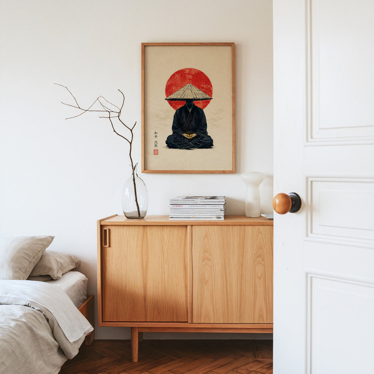 meditating monk in straw hat with red sun print in an oak frame above an oak sideboard in a bedroom with linen bedding
