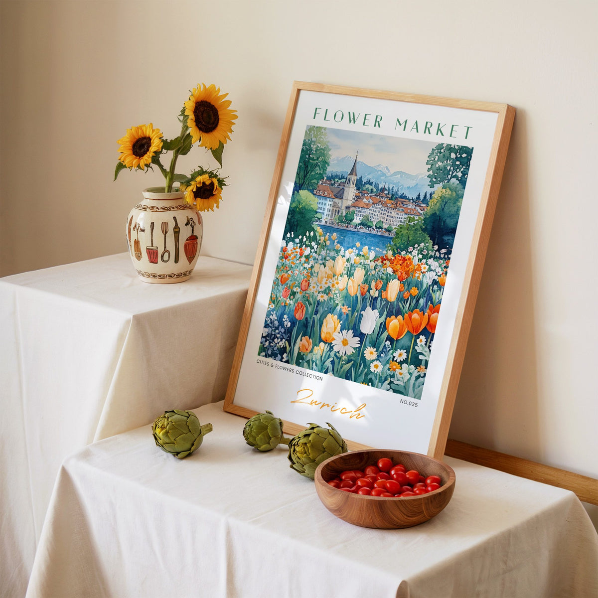 Zurich flower market print in an oak frame leaning on a linen-draped table beside a vase of sunflowers