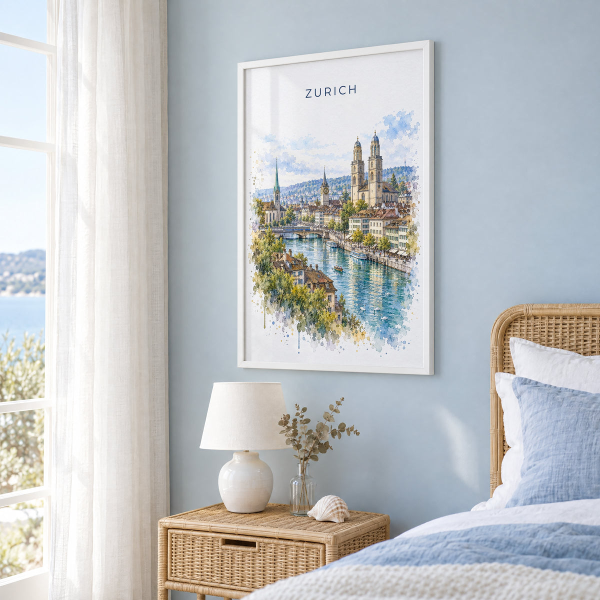 Zurich watercolor print in a white frame on a pale blue wall beside a rattan bed in a coastal bedroom